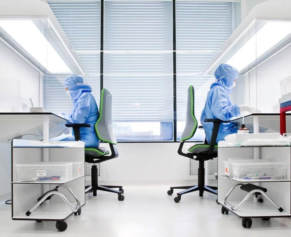 2 techniciens en combinaison stérile assemblent des implants Cousin